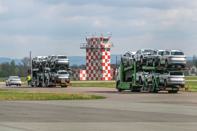 Nákladní automobily přivážejí osobní vozy značky Škoda na letiště v Hradci Králové. Automobilka tam skladuje vozy, jejichž výrobu nemůže kvůli chybějícím čipům dokončit.