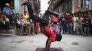 People watch as Drumpal Choudhary, 11, a street performer, performs his tricks on a street in Kathmandu August 15, 2012. Drumpal and his siblings Shivani and Gchan, who came to Kathmandu from India 5 years ago, earn their living by performing tricks on the streets of Kathmandu. According to Drumpal they earn around $10 a day by performing tricks, which is not enough to feed their 10-member family living together in a small hut without a proper toilet or any basic needs. REUTERS/Navesh Chitrakar (NEPAL - Tags: SOCIETY POVERTY IMMIGRATION) Published: Srp. 15, 2012, 4:38 odp.