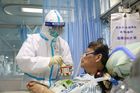 Zdravotní personál v ochranném obleku ošetřuje pacienta v karanténě v nemocnici ve Wu-chanu.