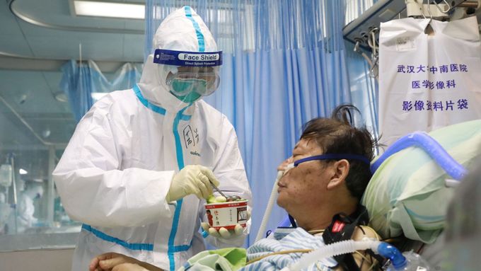Zdravotní personál v ochranném obleku ošetřuje pacienta v karanténě v nemocnici ve Wu-chanu.
