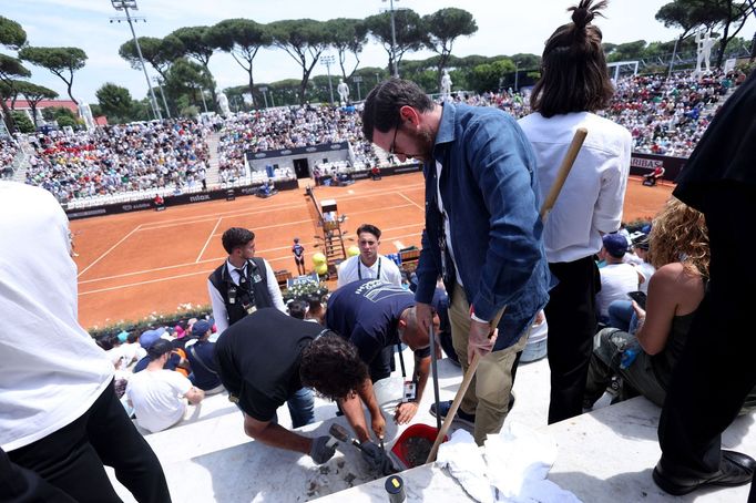 Pracovníci areálu čistí schody od lepidla, kterým se na turnaji v Římě přilepil k ochozům ekologický aktivista