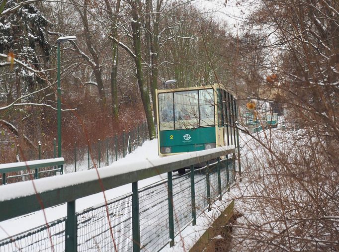 Policista hlídkující před vstupem do haly lanové dráhy.