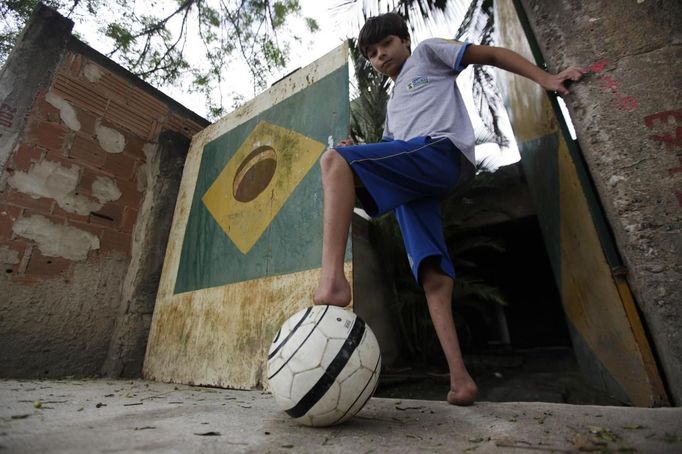 Gabriel Muniz, 11, poses with a soccer ball outside his house in Campos dos Goytacazes, 274 kilometres (170 miles) northeast of Rio de Janeiro August 23, 2012. Despite being born with malformation of his feet, fourth grader Gabriel puts in hours into soccer everyday in his neighbourhood. He aspires to be a professional soccer player just like his idol Argentina's Lionel Messi of Barcelona FC. REUTERS/Ricardo Moraes (BRAZIL - Tags: SPORT SOCCER SOCIETY TPX IMAGES OF THE DAY HEALTH) Published: Srp. 24, 2012, 2:25 dop.