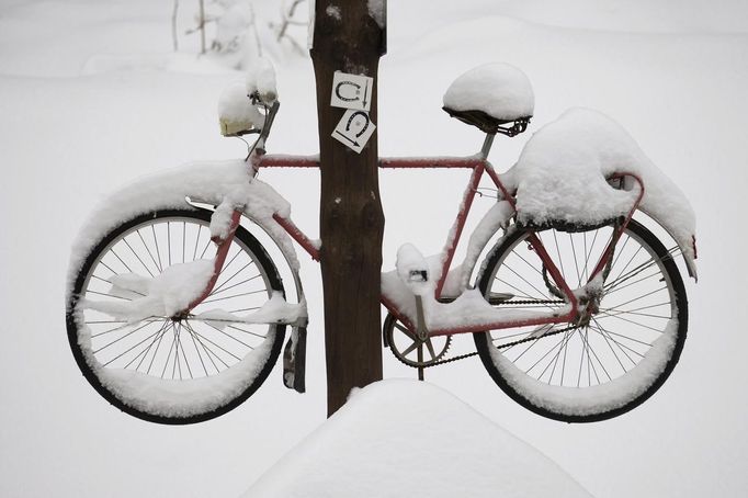 A bicycle that is attached to a pole is covered in snow outside the town of Ilmenau in the south-eastern German state of Thuringia, October 27, 2012. REUTERS/Thomas Peter (GERMANY - Tags: ENVIRONMENT SOCIETY TPX IMAGES OF THE DAY) Published: Říj. 27, 2012, 5:38 odp.