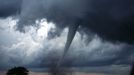 One of several tornadoes observed by the en:VORTEX-99 team on May 3, 1999, in central Oklahoma. Note the tube-like condensation funnel, attached to the rotating cloud base, surrounded by a translucent dust cloud. From this website