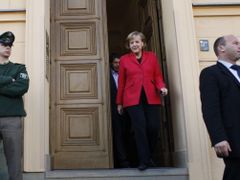 Angela Merkelová vychází z berlínské volební místnosti, za ní její manžel Joachim Sauer.