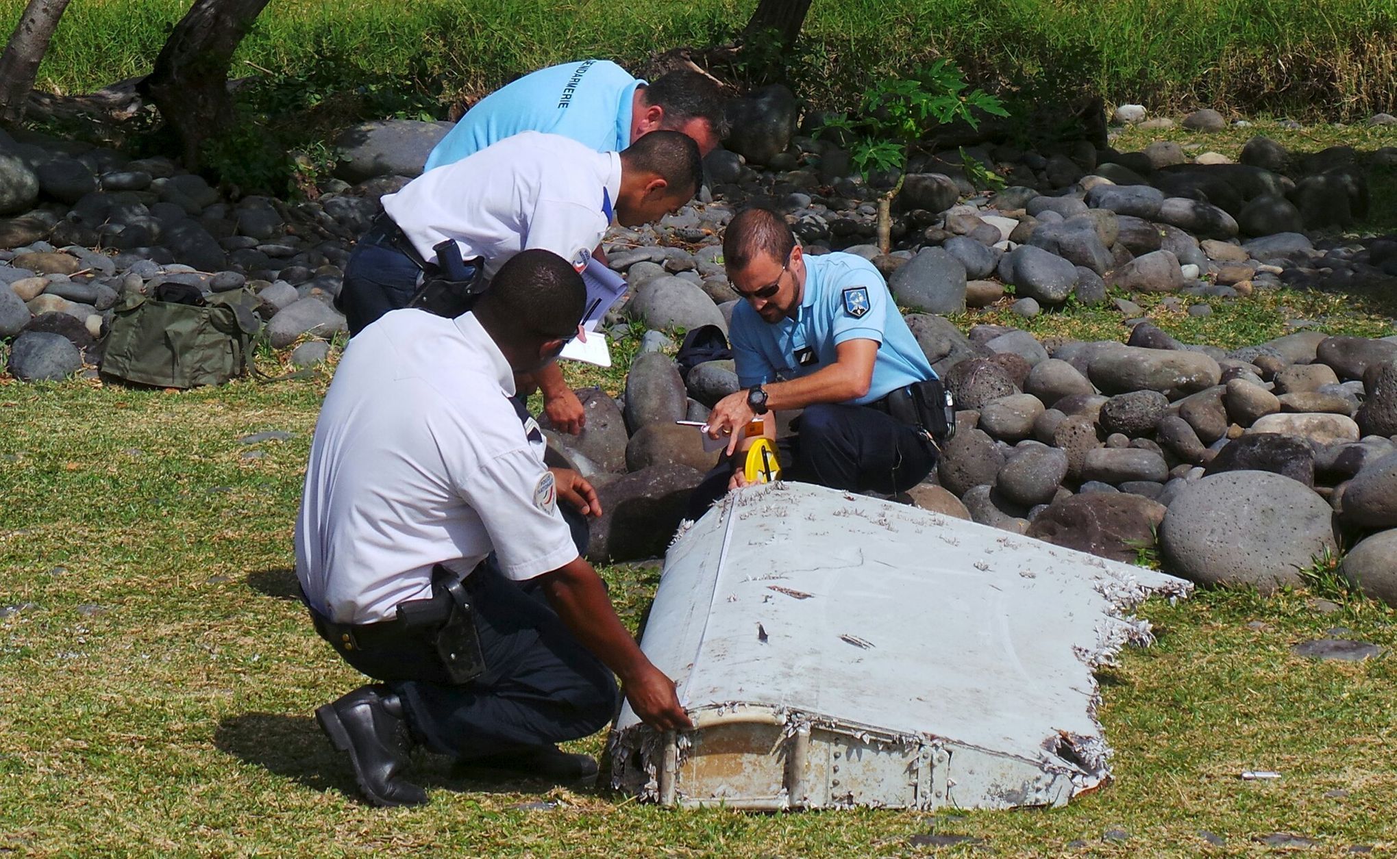 Policisté s nalezeným kusem letadla.
