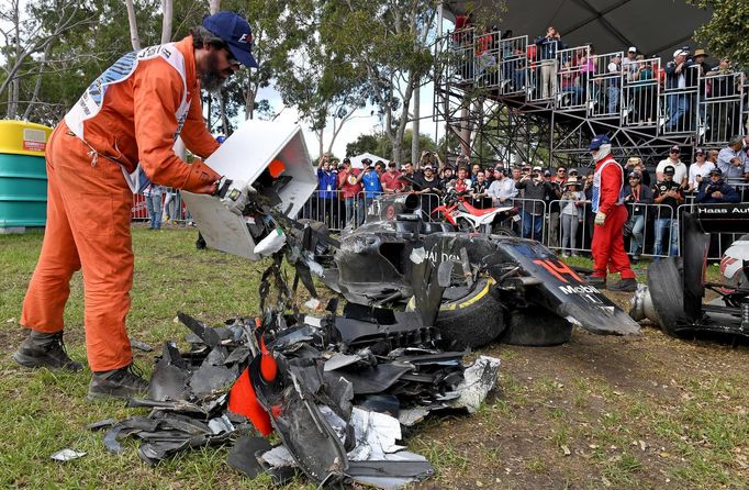 track marshall empties a box of debris collected from a car after a crash during the Australian Formula One Grand Prix in Melbourne.