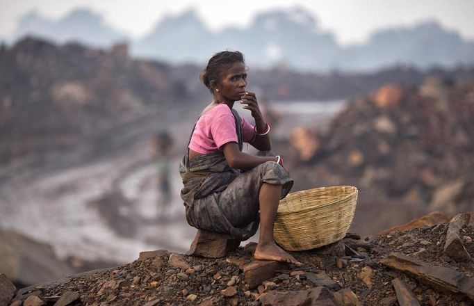 A local woman sits atop of an open cast coal field at Dhanbad district in the eastern Indian state of Jharkhand September 20, 2012. With oil and gas output disappointing and hydropower at full throttle, Asia's third-largest economy still relies on coal for most of its vast energy needs. About 75 percent of India's coal demand is met by domestic production and, according to government plans, that won't change over the next five years. Picture taken September 20, 2012. To match INDIA-COAL/ REUTERS/Ahmad Masood (INDIA - Tags: BUSINESS EMPLOYMENT ENERGY SOCIETY ENVIRONMENT) Published: Říj. 21, 2012, 10:19 odp.