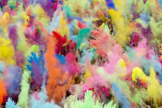 People throw coloured powder in the air during Holi festival celebrations in Berlin, July 29, 2012. Holi, also known as the festival of colours, is a festival celebrated in India and other Hindu countries that in its original form heralds the beginning of spring. The Berlin event brought Indian Djs, acrobatics and dance to the German capital. REUTERS/Thomas Peter (GERMANY - Tags: TPX IMAGES OF THE DAY SOCIETY) Published: Čec. 29, 2012, 3:21 odp.