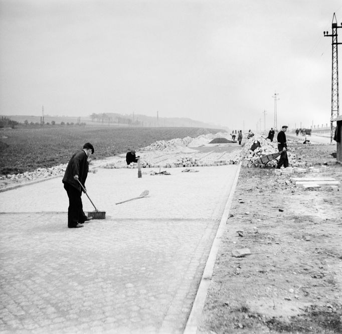 Dlaždiči při práci na stavbě přeložky státní silnice liberecké a Třebízského ulice ve Vysočanech, rok 1938