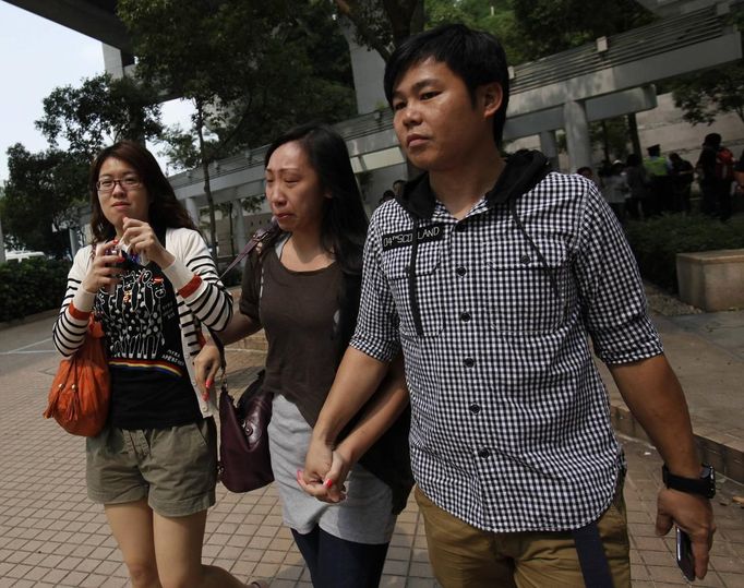 A relative (C) cries as she leaves a public mortuary keeping the bodies of those who died in a boat accident in Hong Kong October 2, 2012. At least 36 people died and dozens were injured when a ferry carrying more than 120 people on a company outing collided with another ferry and sank near an island south of Hong Kong on Monday night in one of the city's worst maritime accidents. REUTERS/Bobby Yip (CHINA - Tags: DISASTER TRANSPORT) Published: Říj. 2, 2012, 3:41 dop.