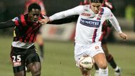 Nová posila Lyonu Milan Baroš (vpravo) se snaží s míčem uniknout Onyekachi Apamovi z Nice.