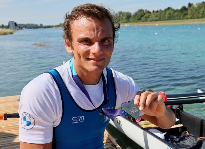 2022 European Championships - Rowing - Olympic Regatta Centre, Munich, Germany - August 13, 2022 Gold medallist Italy's Giacomo Perini celebrates with a medal after winni