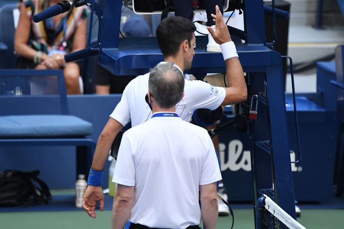 Sep 6, 2020; Flushing Meadows, New York, USA; Novak Djokovic of Serbia discusses with a tournament official after being defaulted for striking a lines person with a ball