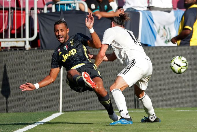 Medhi Benatia (4) z Juventusu v souboji s hráčem Realu Garethem Balem (11)