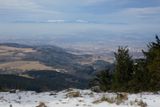 V nižších polohách je to již slabší. Pohled z hřebene Orlických hor přes travnatou nížinu na zasněžené Krkonoše.