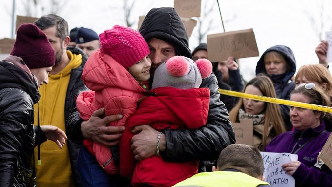 Muž objímá své dcery poté, co přijely z Ukrajiny do Přemyšlu v Polsku.
