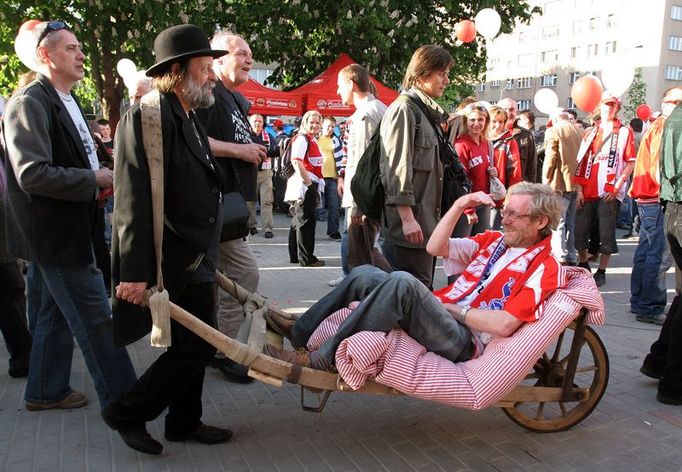 Členové Balbínovy politické strany přivezli na otevření stadionu kritika a publicistu Jana Rejžka na trakaři. Že by nějaká sázka?