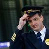 Handwerg, spokesman of Vereinigung Cockpit, the union for pilots of Lufthansa, adjusts his pilot's hat before posing in front of a flight schedule board at Fraport airport in Frankfurt