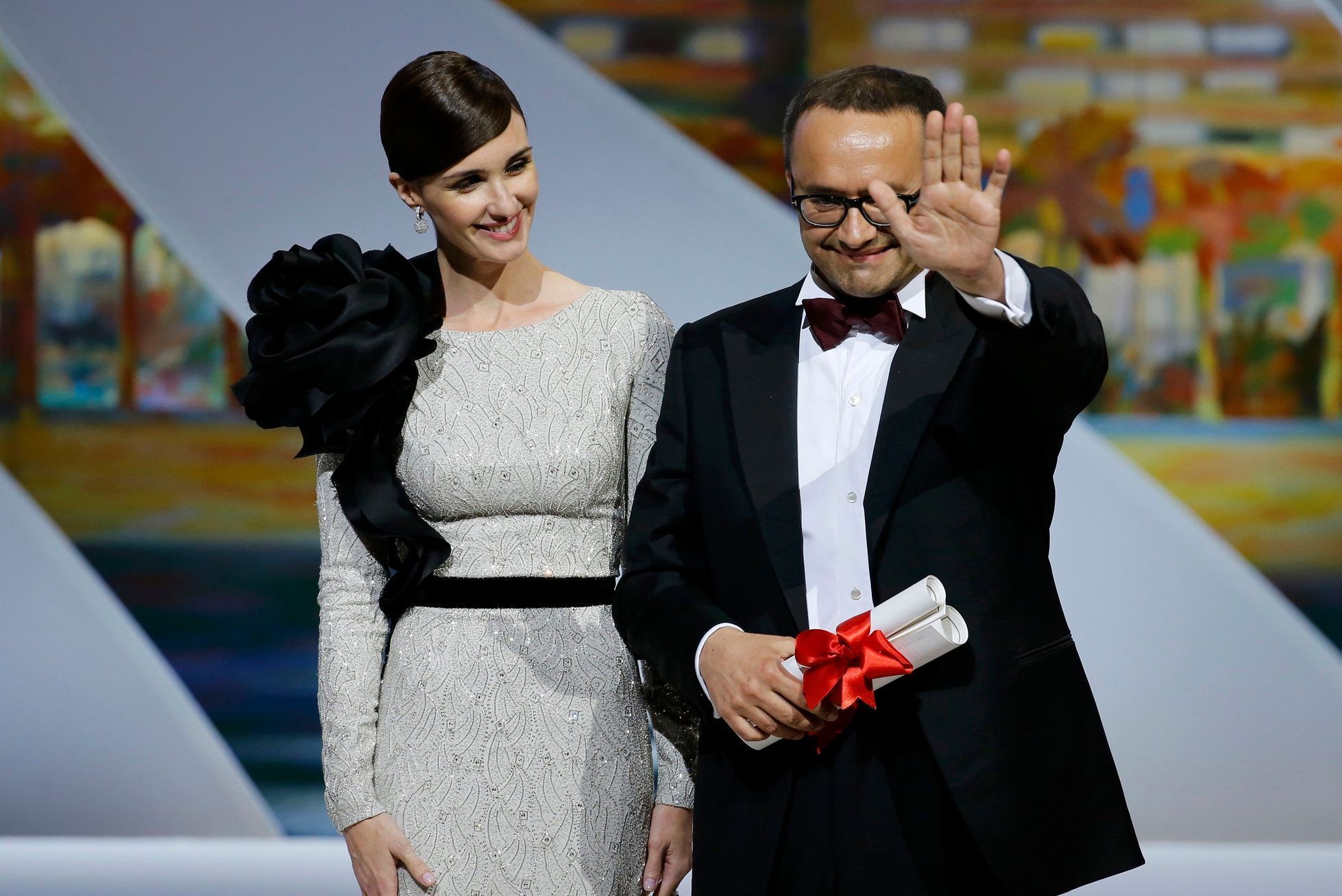 Director Andrey Zvyagintsev, Best screenplay award winner for his film &quot;Leviathan&quot;, celebrates on stage next to Spanish actress Paz Vega during the closing ceremony of the 67th Cannes Film F