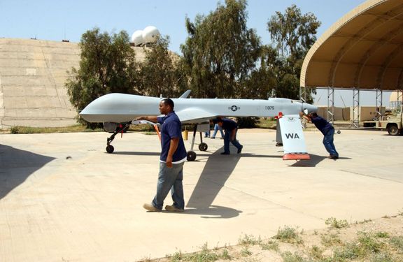Údržbáři vytlačují dron MQ-1 Predator z hangáru. Irák, 26. dubna 2006.
