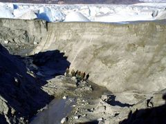 Vědci stojí v místech na dně kráteru, kde ještě před pár dny bývala voda