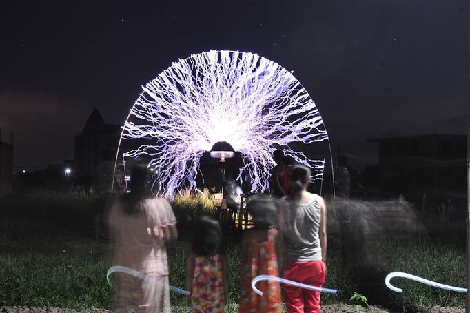 Performing With Lightning CHANGLE, CHINA - AUGUST 12: (CHINA OUT) A guitarist plays guitar as high voltage of up to 1 million volts, generated by a Tesla coil transformer, runs through his body during a stunt performance on August 12, 2012 in Changle, Fujian Province of China. Wang Zengxiang, one of the craziest fans of the Tesla coil stunt, has dedicated himself in the daredevil career for a decade. He is now the leader of a band of four. A Tesla coil is an electrical resonant transformer circuit invented by Nikola Tesla around 1891. The transformer produces high voltage at high frequencies, which acts as a giant lightning machine, and creates long bolts of electricity. Shielded by protective clothing, the performer is insulated from the electricity current which dissipates through the ground.