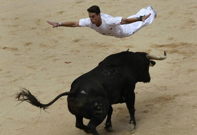 A recortador jumps over a bull during a contest at Pamplona's bullring on the third day of the San Fermin festival July 8, 2012. REUTERS/Joseba Etxaburu (SPAIN - Tags: ANIMALS SOCIETY) Published: Čec. 8, 2012, 12:51 odp.