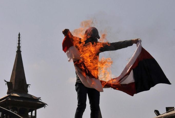 Protestující v Kašmíru pálí americkou vlajku.