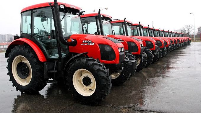 Hotové traktory čekají na parkovišti pod Líšeňským sídlištěm v Praze na expedici. Každý má za předním oknem cedulku místa určení. V současné době se vyváží do více než 40 zemí po celém světě.