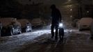 A man walks with his dog in the snow during the nor'easter, also known as a northeaster storm, in Jersey City, New Jersey November 7, 2012. A wintry storm dropped snow and rain on the U.S. Northeast on Wednesday, bringing dangerous winds and knocking out power in a region where hundreds of thousands were still in the dark after Superstorm Sandy. REUTERS/Eduardo Munoz (UNITED STATES - Tags: DISASTER ENVIRONMENT)