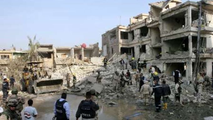 Vojáci a záchranáři prohlížejí obytný dům v centru Bagdádu, který srovnaly se zemí bomby ukryté ve dvou autech.