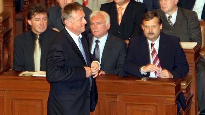 Mirek Topolánek opouští sněmovnu podél lavic, v nichž sedí levicoví poslanci.