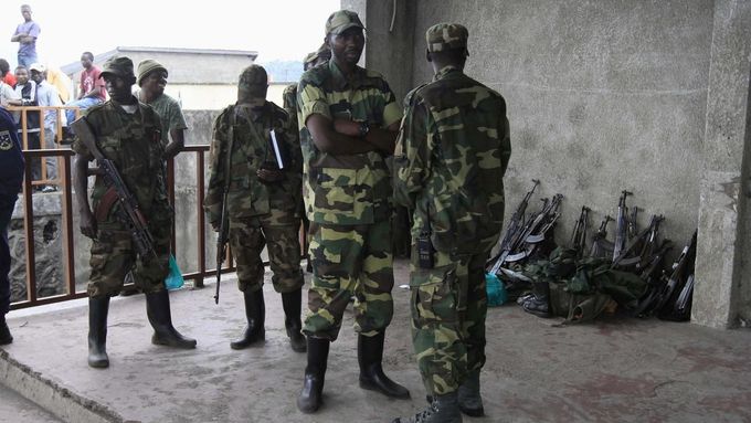 Členové povstalecké skupiny M23 střeží zbraně, které jim odevzdali konžští vojáci.