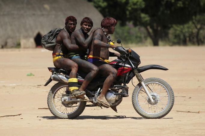 Yawalapiti men ride a motorcycle during a break in this year's 'quarup,' a ritual held over several days to honour in death a person of great importance to them, in the Xingu National Park, Mato Grosso State, August 19, 2012. This year the Yawalapiti tribe honoured two people - a Yawalapiti Indian who they consider a great leader, and Darcy Ribeiro, a well-known author, anthropologist and politician known for focusing on the relationship between native peoples and education in Brazil. Picture taken August 19, 2012. REUTERS/Ueslei Marcelino (BRAZIL - Tags: SOCIETY ENVIRONMENT TRANSPORT) FOR EDITORIAL USE ONLY. NOT FOR SALE FOR MARKETING OR ADVERTISING CAMPAIGNS. ATTENTION EDITORS - PICTURE 21 OF 37 FOR THE PACKAGE 'THE YAWALAPITI QUARUP RITUAL' Published: Srp. 29, 2012, 10:21 dop.