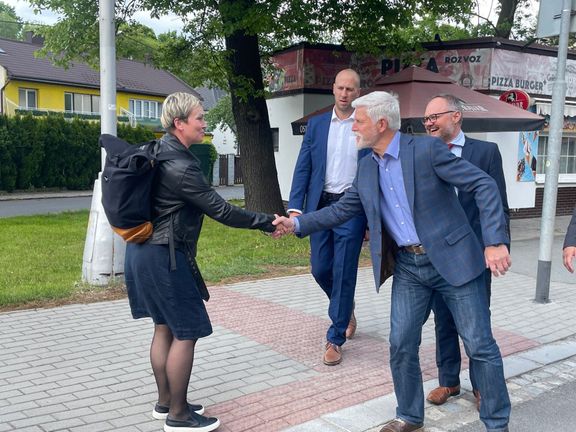 Prezident Petr Pavel se zdraví s kolemjdoucí ženou při své cestě z radnice v Bruntále na besedu s občany,