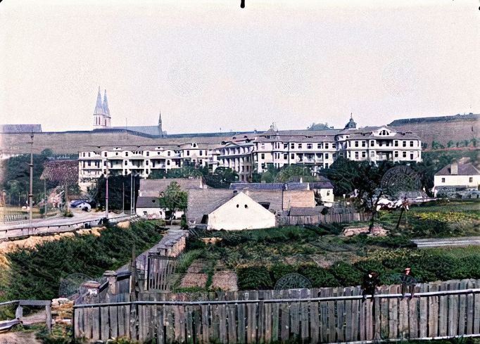 Celkový pohled na sanatorium (dům čp. 157 v Podolí) na Podolském nábřeží. V pozadí vlevo věže kostela sv. Petra a Pavla na Vyšehradě, v popředí zelinářská zahrada. 1915