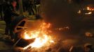 A man throws a tyre on another burning tyre, which is blocking an entrance of Mercabarna (wholesale market) at Zona Franca, in Barcelona November 14, 2012. Spain's two largest labour unions have called for a general strike on November 14, the second against the conservative government since they took power in December and coinciding with industrial action in Portugal on the same day. REUTERS/Albert Gea (SPAIN - Tags: BUSINESS EMPLOYMENT POLITICS CIVIL UNREST) Published: Lis. 14, 2012, 1:12 dop.