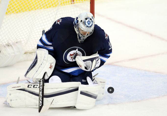 Ondřej Pavelec zasahuje proti střele Jiřího Hudlera.