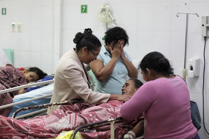 Family members react while standing next to a woman who died after she was hit by a stray bullet during a shoot-out between rival gangs in San Pedro Sula March 27, 2013. San Pedro Sula, the country's second largest city after Tegucigalpa, has a homicide rate of 169 per 100,000 people and was named the world's most violent city for a second year in a row. Lax laws allow civilians to own up to five personal guns. Arms trafficking has flooded the country with nearly 70% illegal firearms. 83.4% of homicides are by firearms, compared to 60% in the United States. Picture taken March 27, 2013. REUTERS/Jorge Cabrera (HONDURAS - Tags: CRIME LAW CIVIL UNREST HEALTH) ATTENTION EDITORS: PICTURE 22 OF 39 FOR PACKAGE 'GUN CULTURE - HONDURAS' SEARCH 'HONDURAS GUN' FOR ALL IMAGES Published: Dub. 5, 2013, 11:15 dop.