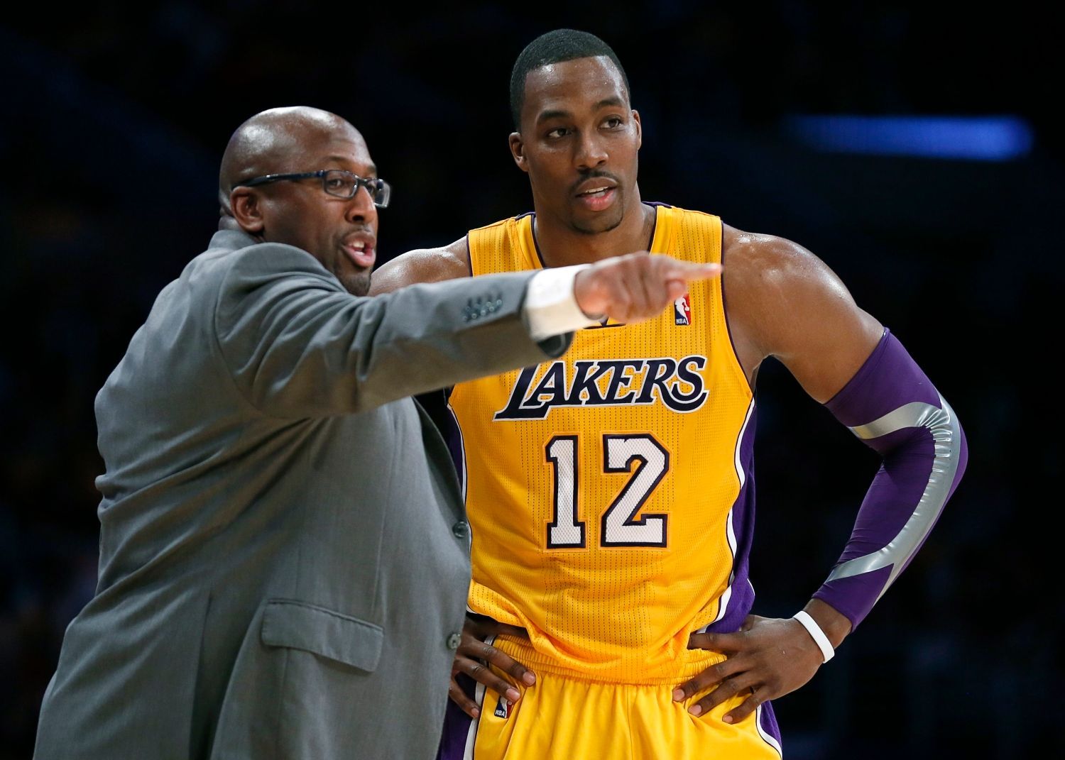 Basketbalista Los Angeles Lakers Dwight Howard poslouchá instrukce trenéra Mika Browna v utkání NBA 2012/13 proti Dallasu Maverics.