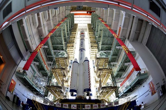 The Shenzhou-9 manned spacecraft, Long March-2F rocket, and escape tower wait to be transferred to the launch pad at the Jiuquan Satellite Launch Center, Gansu province June 9, 2012. China will launch its Shenzhou-9 manned spacecraft sometime in mid-June to perform the country's first manned space docking mission with the orbiting Tiangong-1 space lab module, a spokesperson with the country's manned space program said here Saturday, Xinhua News Agency reported. REUTERS/China Daily (CHINA - Tags: SCIENCE TECHNOLOGY TPX IMAGES OF THE DAY) CHINA OUT. NO COMMERCIAL OR EDITORIAL SALES IN CHINA Published: Čer. 9, 2012, 12:31 odp.