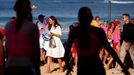 Catherine, Britain's Duchess of Cambridge, carries a bag as she walks next to junior surf lifesavers during a visit to Sydney's Manly beach