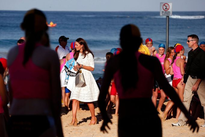 Catherine, Britain's Duchess of Cambridge, carries a bag as she walks next to junior surf lifesavers during a visit to Sydney's Manly beach