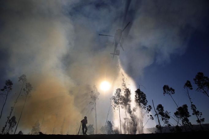 A helicopter drops water over a forest fire in Alvaiazere, near Ourem September 4, 2012. More 10 fires are active in Portugal, according to the Civil Defence. REUTERS/Rafael Marchante (PORTUGAL - Tags: SOCIETY DISASTER ENVIRONMENT TPX IMAGES OF THE DAY) Published: Zář. 4, 2012, 9:47 dop.