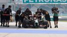 Mechanics push the car of Lotus Formula One driver Pastor Maldonado of Venezuela down the pit lane during the first practice session of the Malaysian F1 Grand Prix at Sep