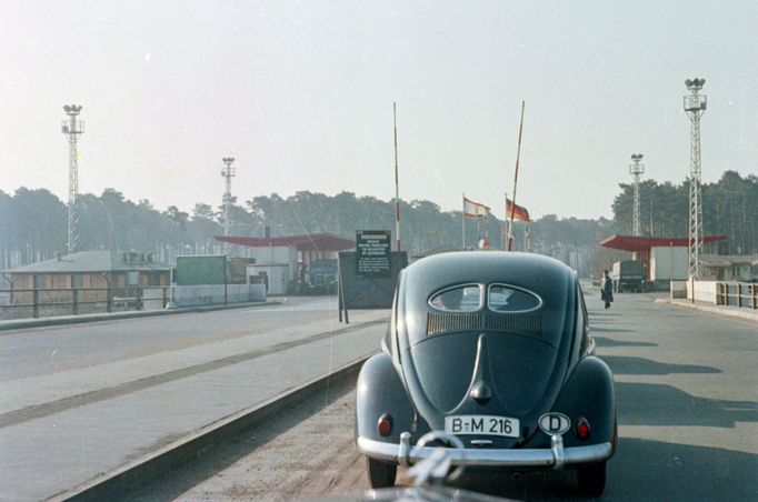 Volkswagen Brouk na hraničním přechodu Heerstrasse / Staaken mezi Západním Berlínem a NDR v roce 1957. V pozadí jsou vidět strážní věže a vlajky.