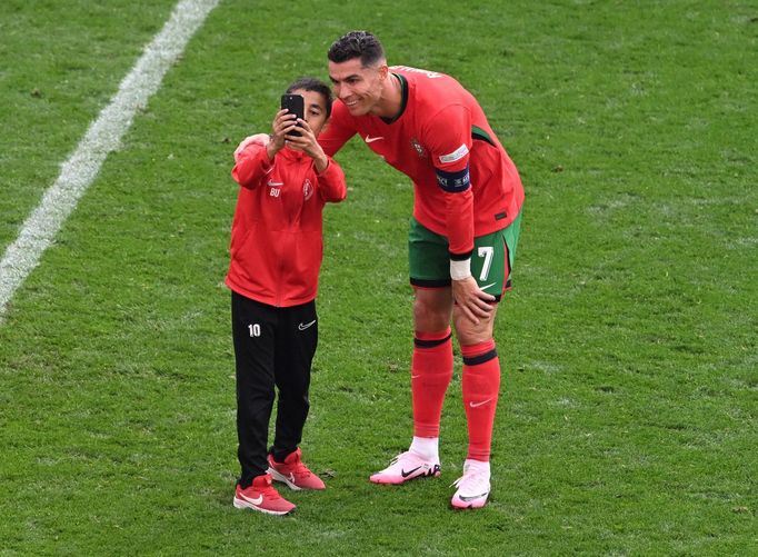 Soccer Football - Euro 2024 - Group F - Turkey v Portugal - Dortmund BVB Stadion, Dortmund, Germany - June 22, 2024 Young pitch invader takes a selfie with Portugal's Cri