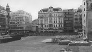 Na místě dnešního obchodního domu stával až do roku 1938 novogotický Šlikovský palác od architekta Josefa Krannera. Po jeho demolici stál na rohu Národní a Spálené ulice dřevěný pavilon. Na snímku parcela v roce 1972.